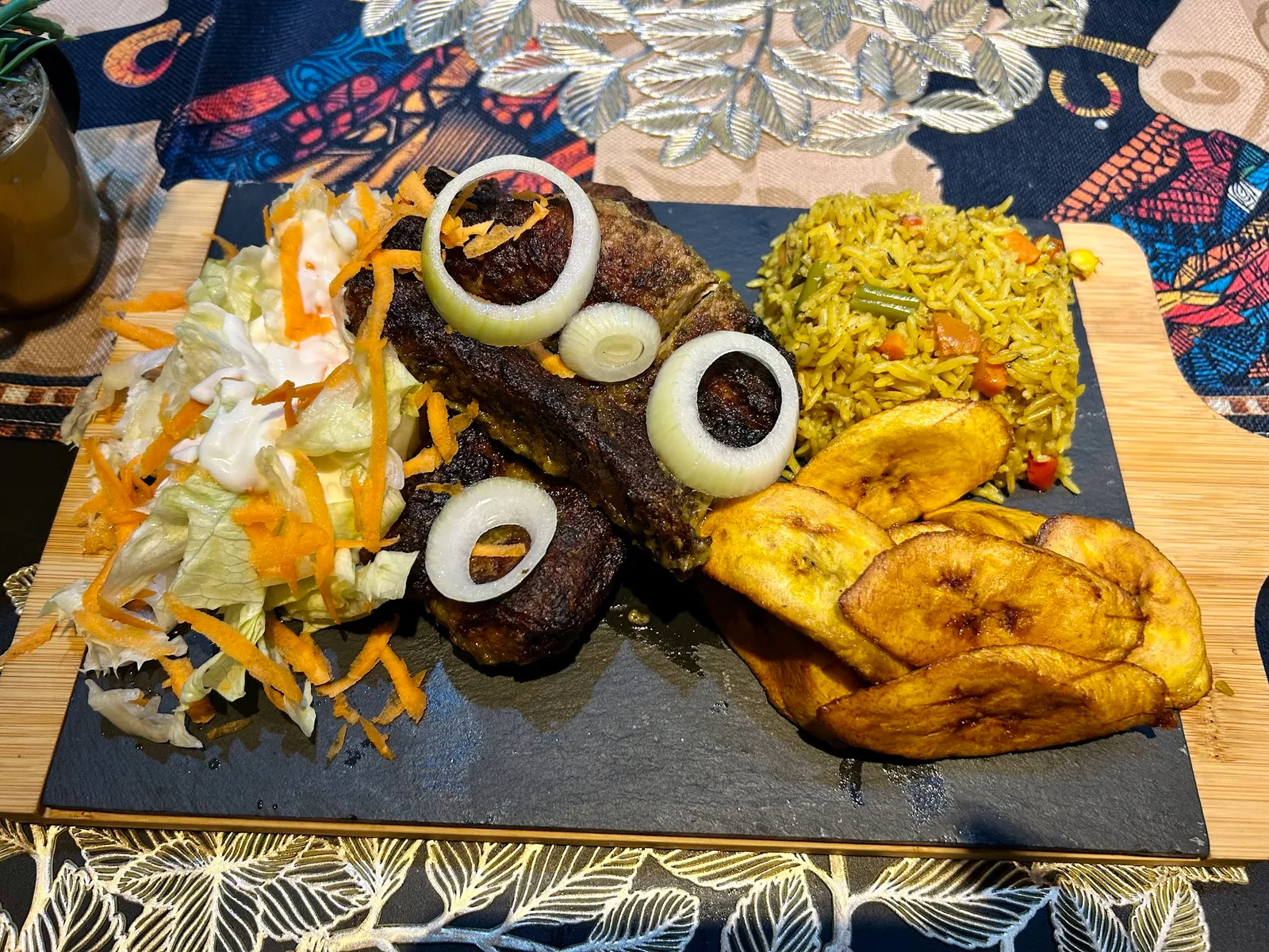 Grillteller mit Fleisch, Bratreis und Kochbananen