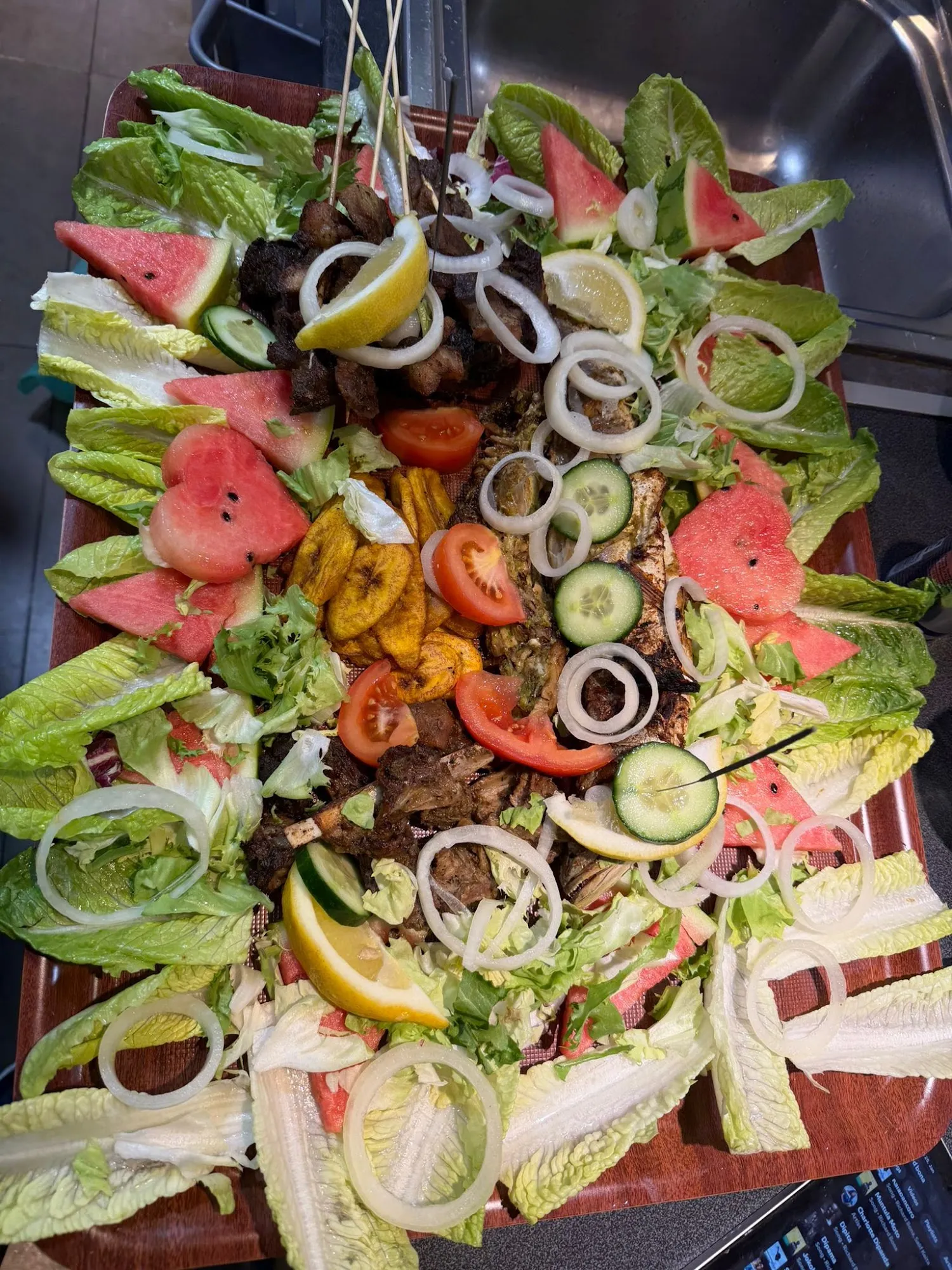 Große Grillplatte mit Fleisch, Fisch und Kochbananen